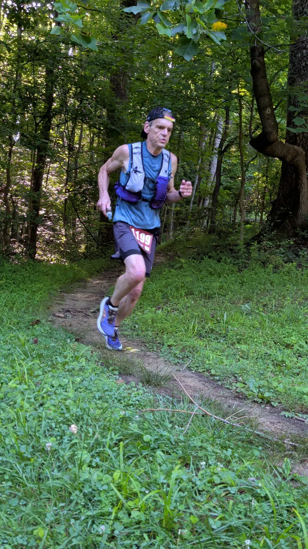 Derek running a forest trail during an ultramarathon